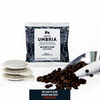 three espresso pods, coffee beans and coffee scoop with a blue pod pouch mezzanotte decaf